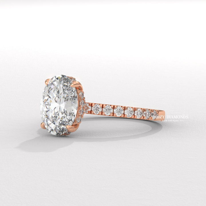 Oval hidden halo engagement ring viewed from the side