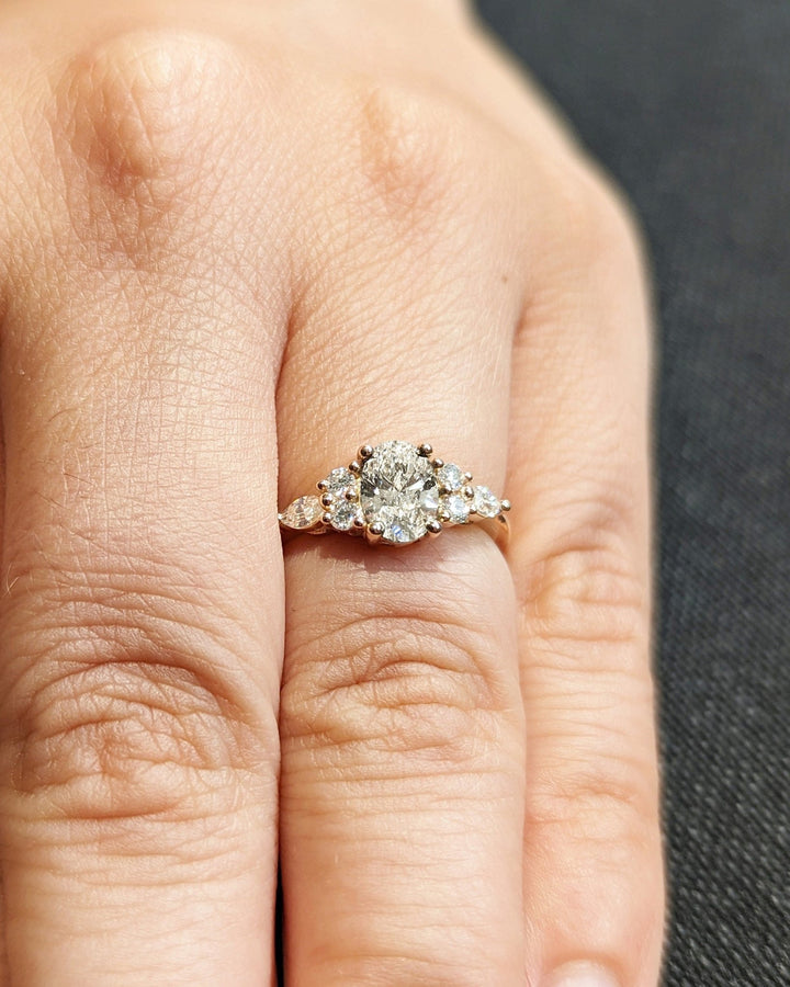Oval cut cluster engagement ring shown in real-life wear