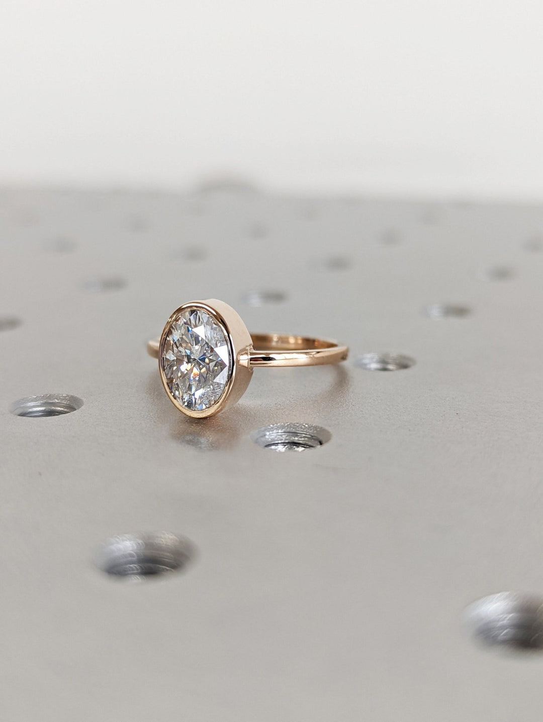 Oval bezel engagement ring finished in polished solid gold
