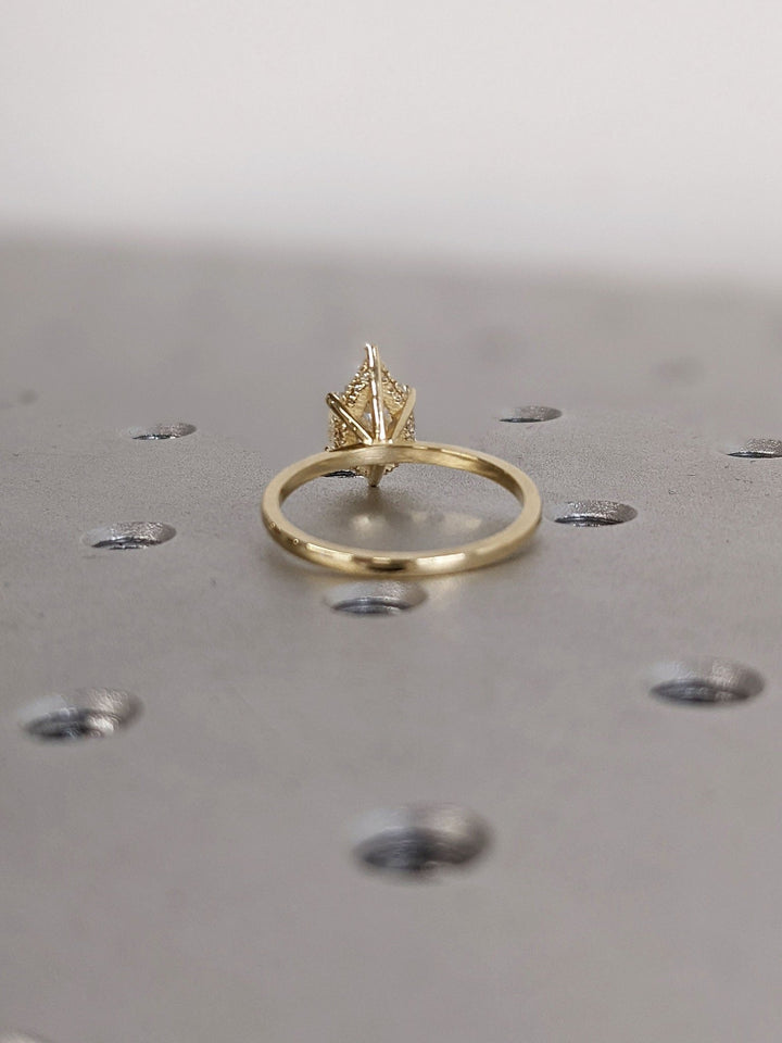 Macro shot of pear cut diamond facets in hidden halo ring setting
