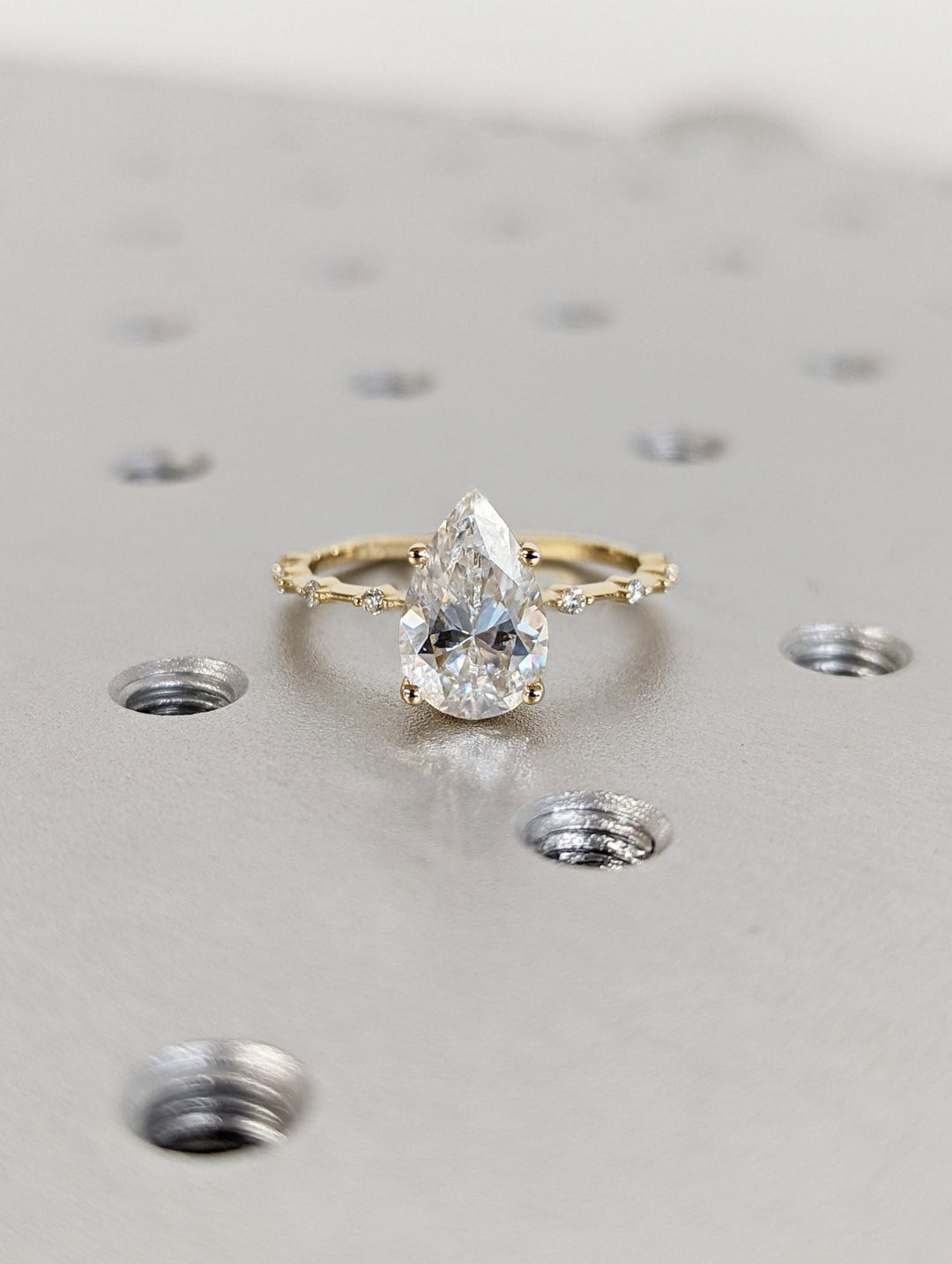 Pear pave engagement ring shown on hand for true-to-life sizing
