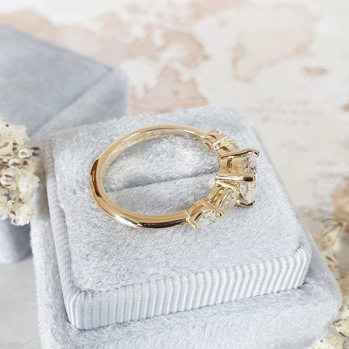 Round cut five stone engagement ring shown in real-life wear