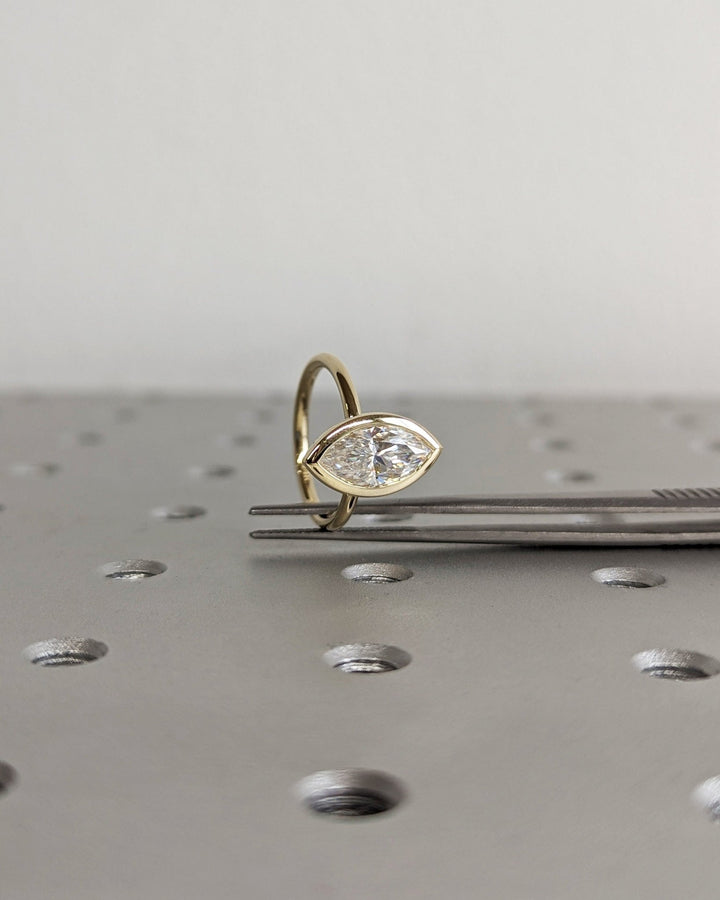 Angled view of marquise cut diamond in bezel setting
