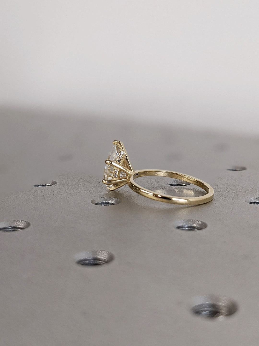 Detailed close-up of pear hidden halo diamond engagement ring