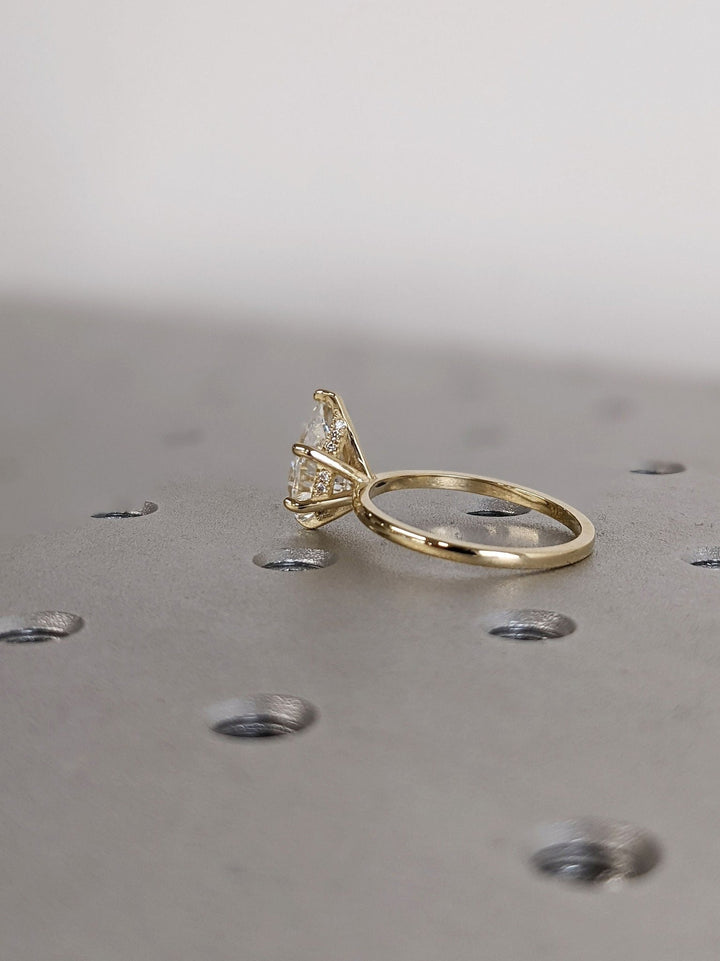 Detailed close-up of pear hidden halo diamond engagement ring