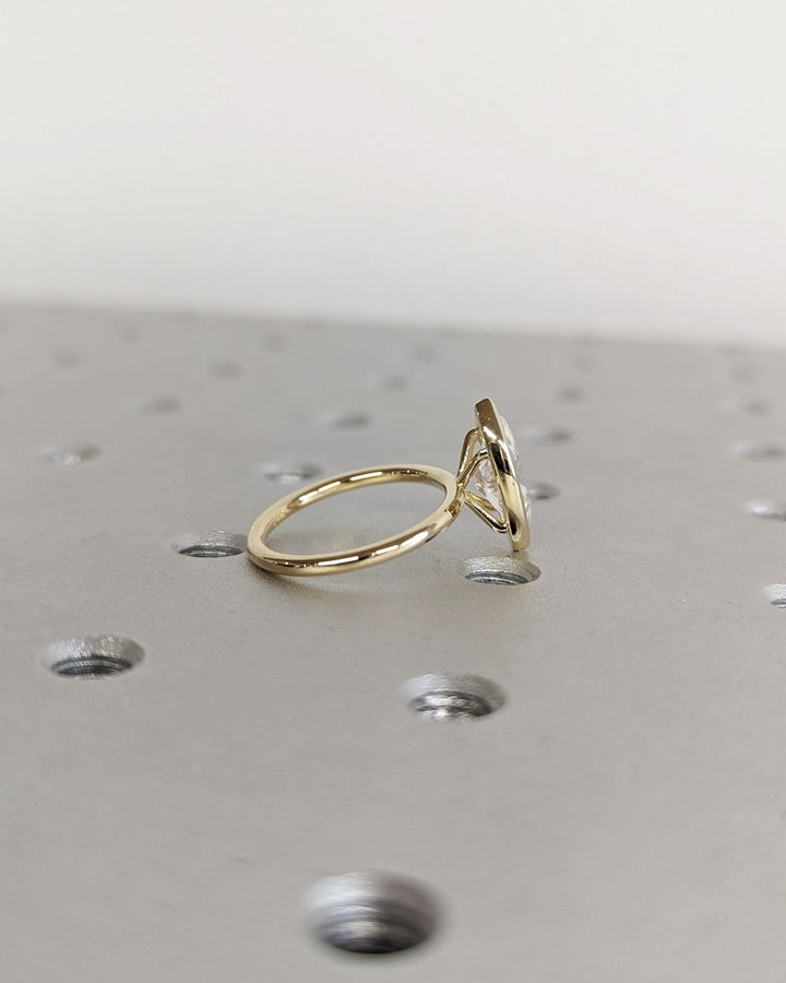 Marquise bezel diamond ring displayed on jewelry stand