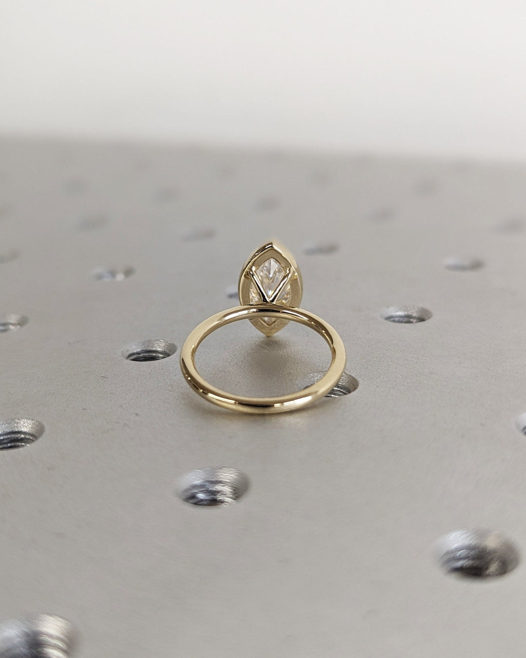 Close-up of marquise cut center diamond in bezel engagement ring