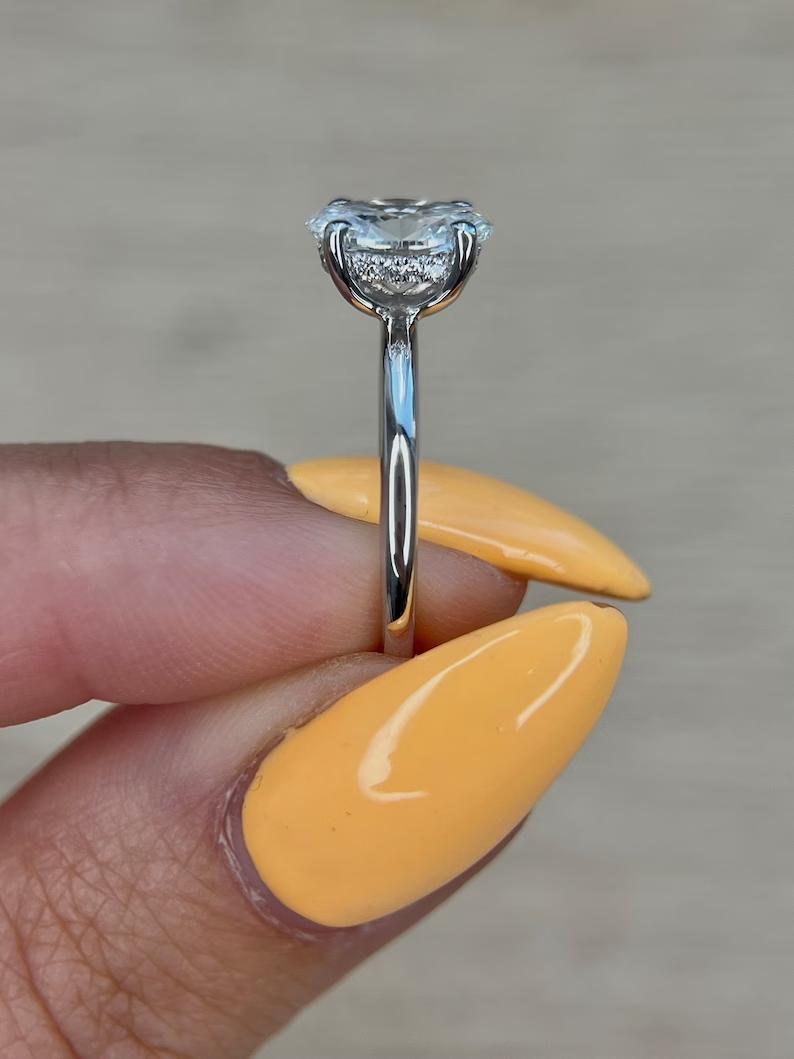 Oval cut engagement ring shown with authenticity certificate