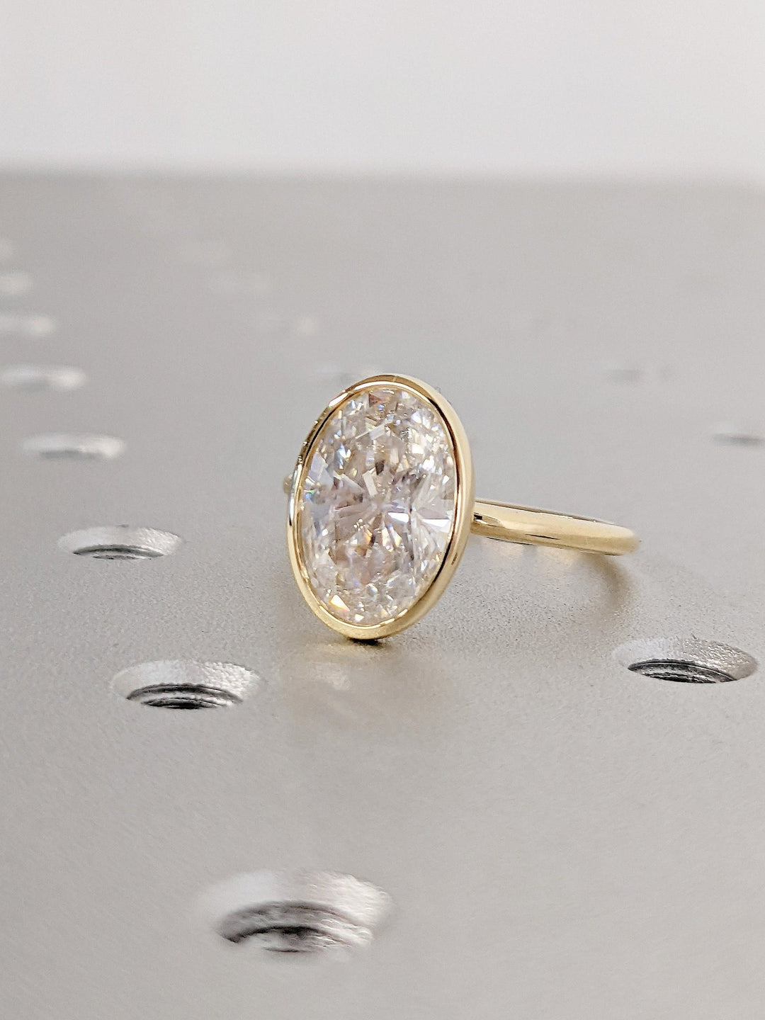 Lifestyle shot of oval bezel diamond ring on hand