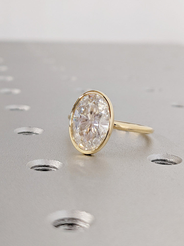 Lifestyle shot of oval bezel diamond ring on hand