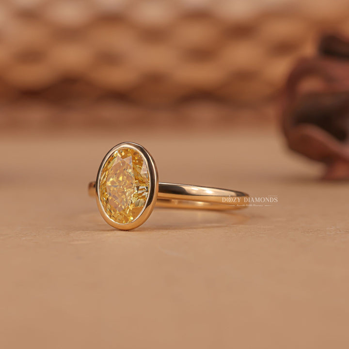 Oval bezel engagement ring shown on hand for true-to-life sizing