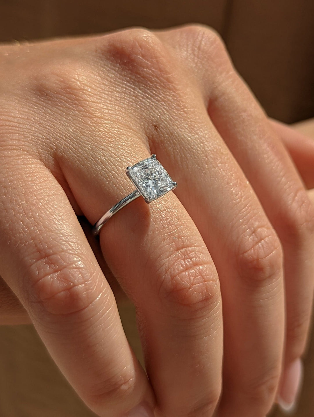 Cushion solitaire engagement ring offered in gold and platinum