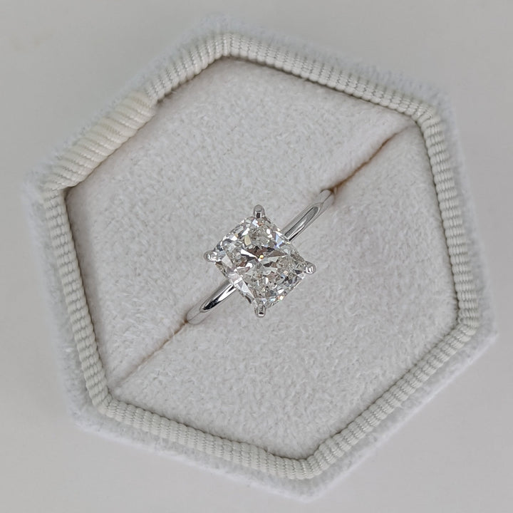 Cushion cut engagement ring shown with authenticity certificate
