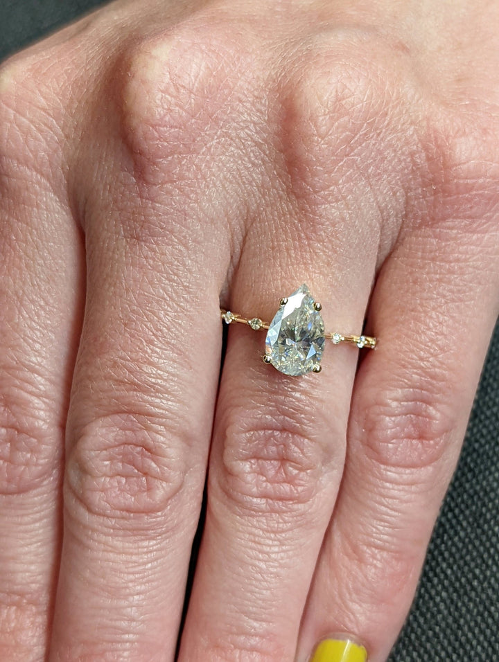 Profile view of pear cut pave engagement ring band