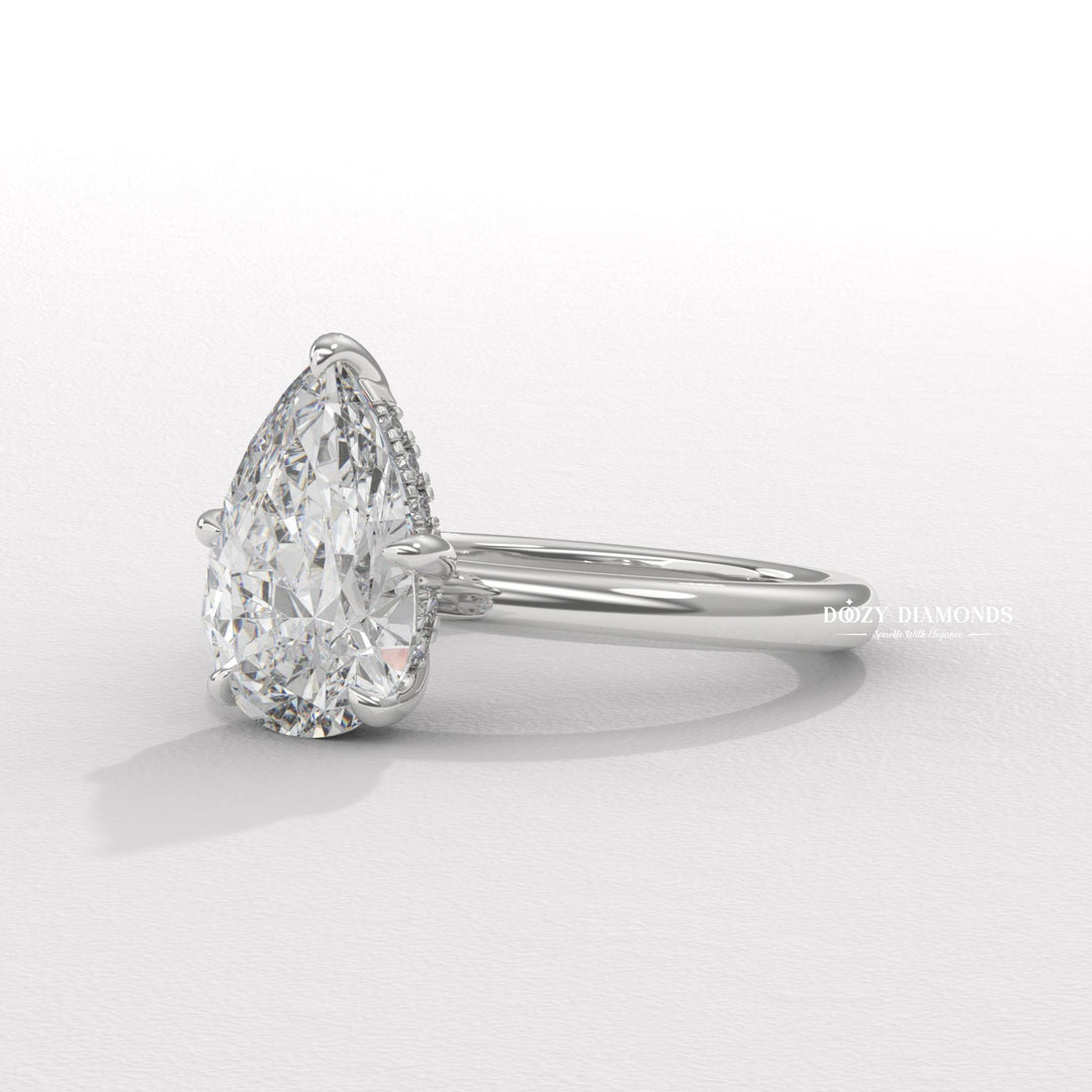 Pear hidden halo engagement ring finished in polished solid gold