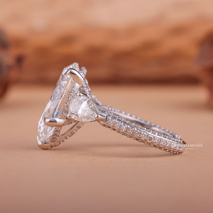 Unboxing view of pear cut three stone diamond engagement ring