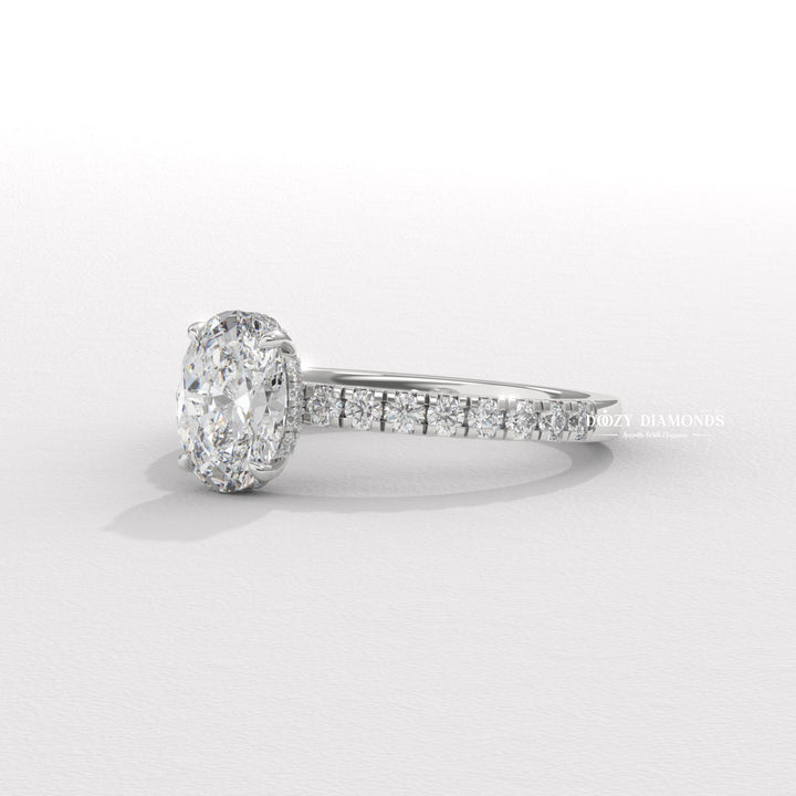 Oval hidden halo diamond ring displayed on jewelry stand