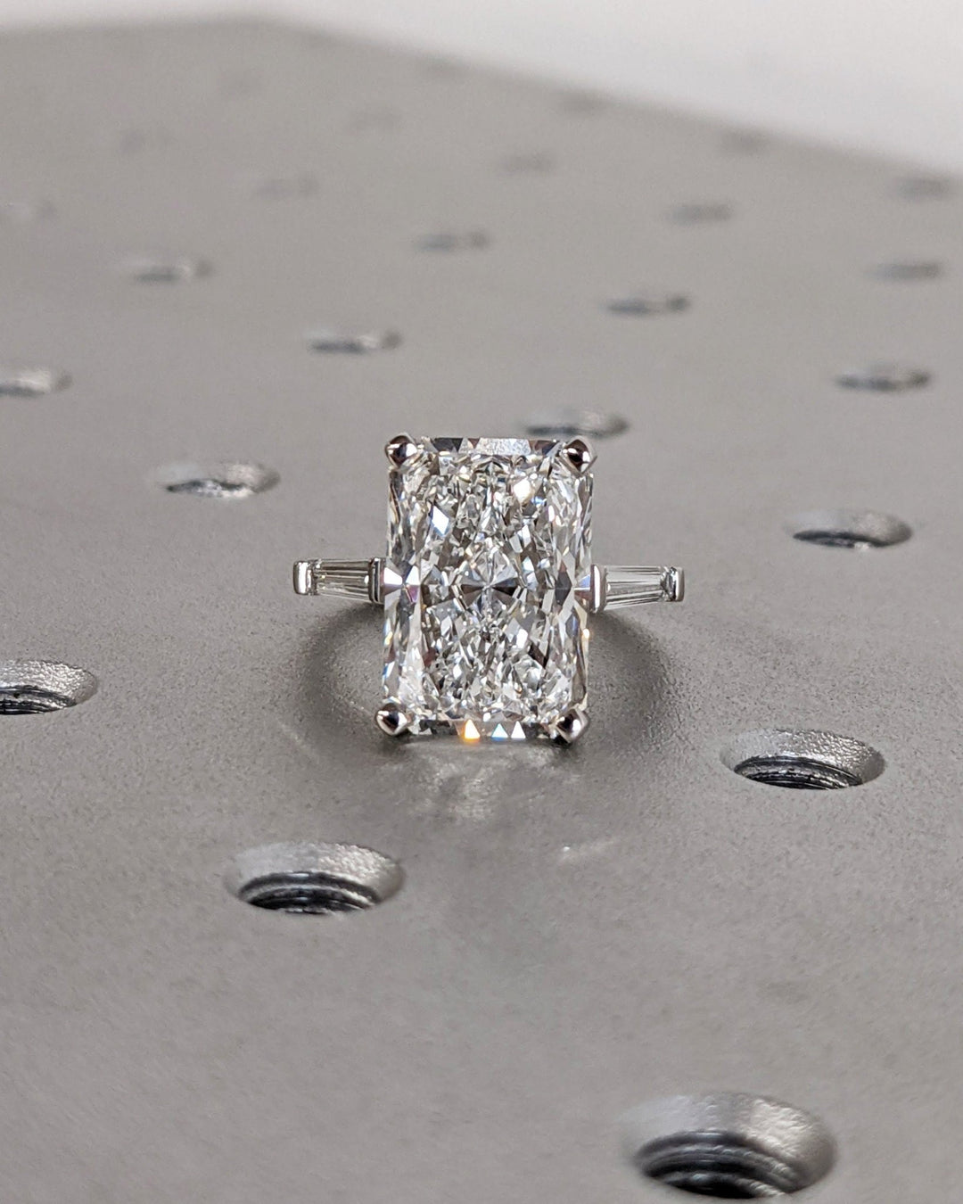 Macro shot of radiant cut diamond facets in three stone ring setting