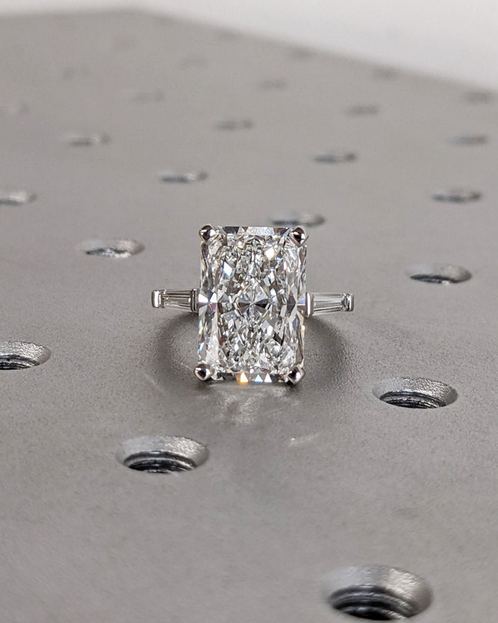 Macro shot of radiant cut diamond facets in three stone ring setting