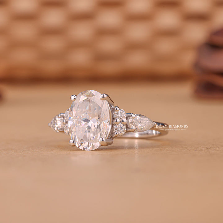 Oval cluster engagement ring shown on hand for true-to-life sizing