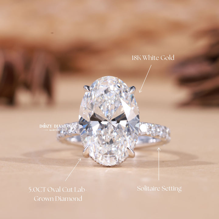Oval hidden halo engagement ring offered in gold and platinum