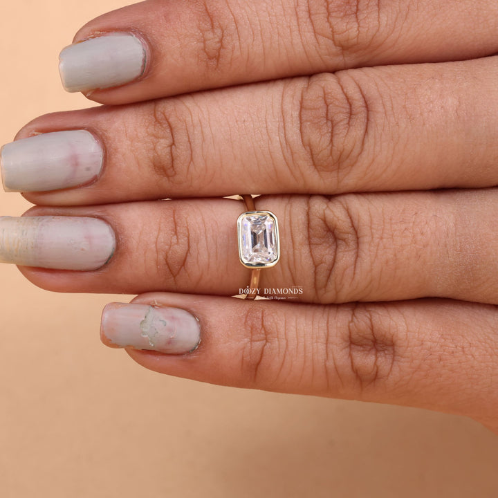 Lifestyle shot of emerald bezel diamond ring on hand