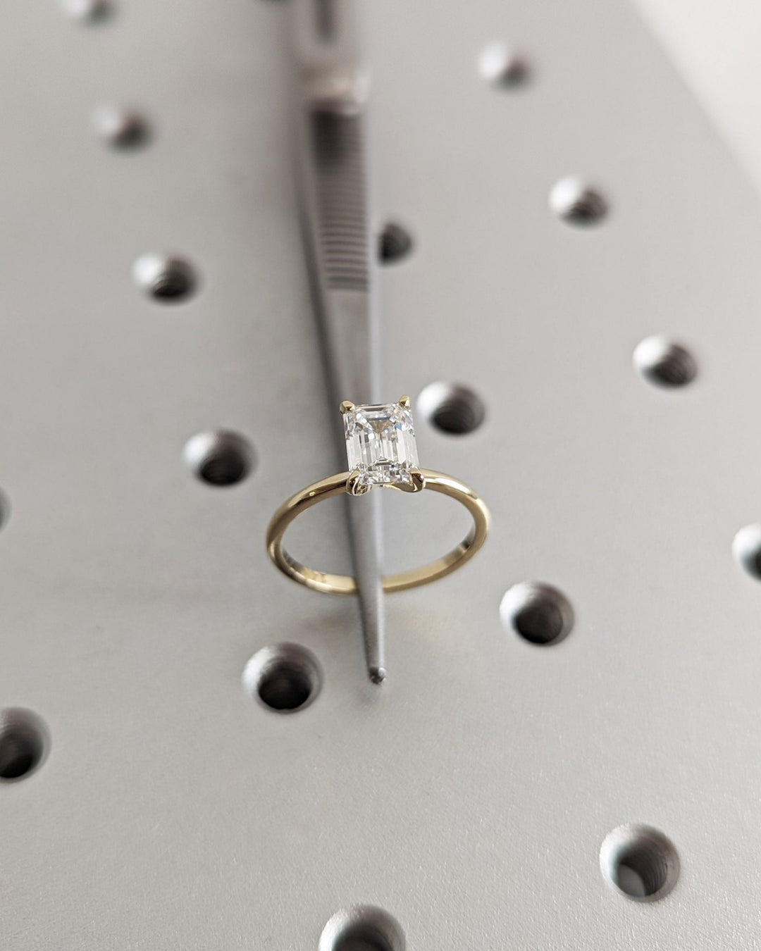 Emerald solitaire engagement ring shown on hand for true-to-life sizing