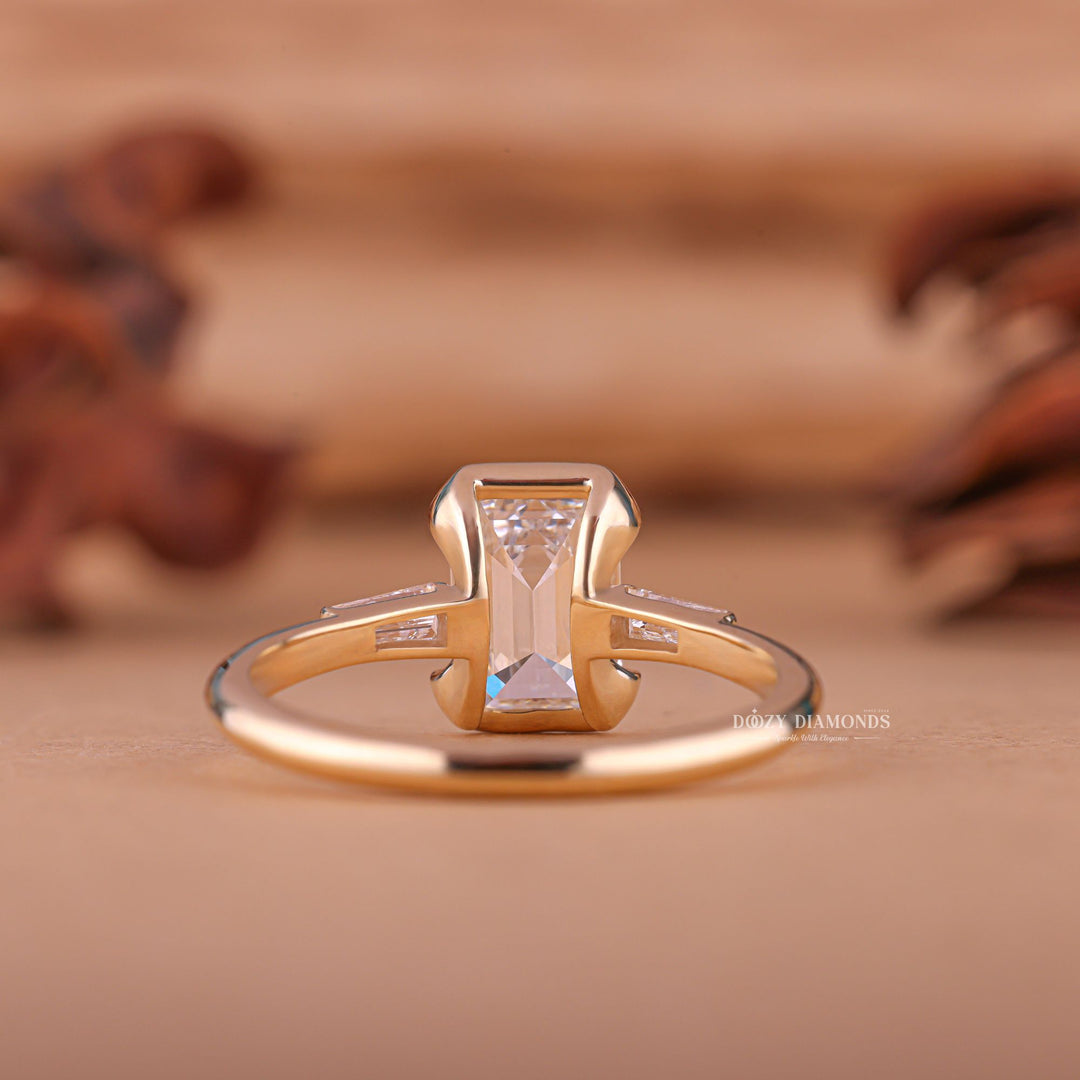 Close-up of emerald cut center diamond in three stone engagement ring