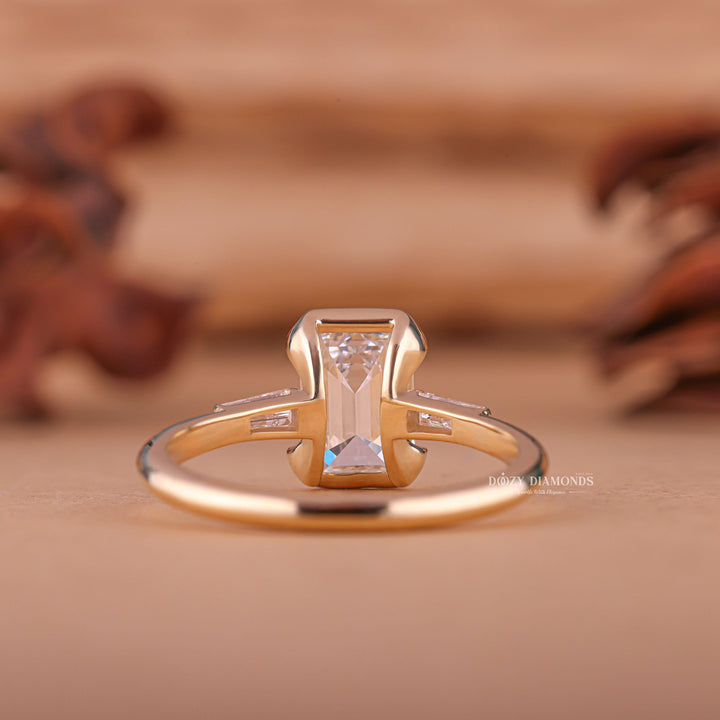 Close-up of emerald cut center diamond in three stone engagement ring
