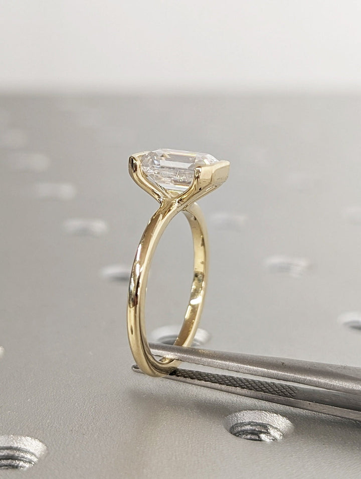 Macro shot of emerald cut diamond facets in bezel ring setting