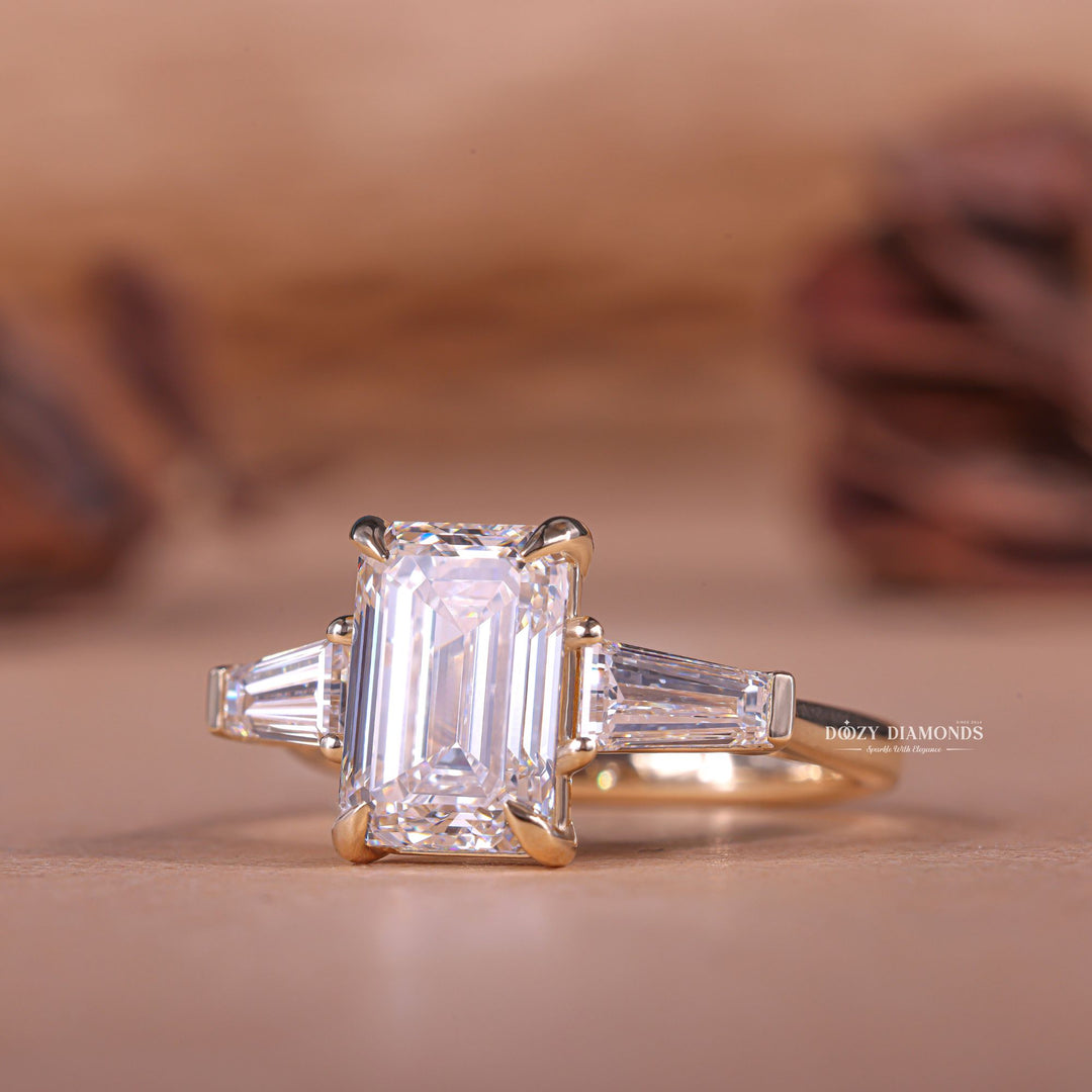 Lifestyle shot of emerald three stone diamond ring on hand