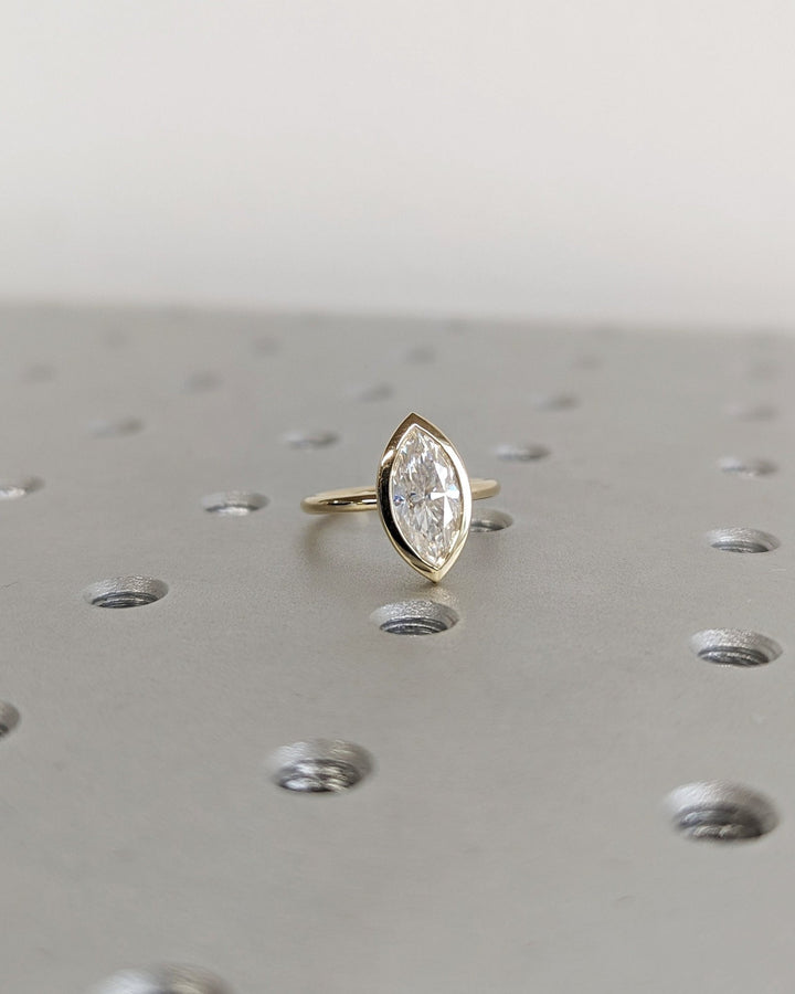 Macro shot of marquise cut diamond facets in bezel ring setting