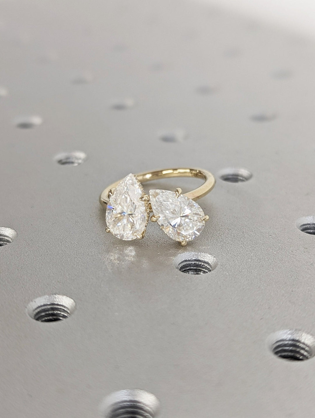 Detailed close-up of pear hidden halo diamond engagement ring