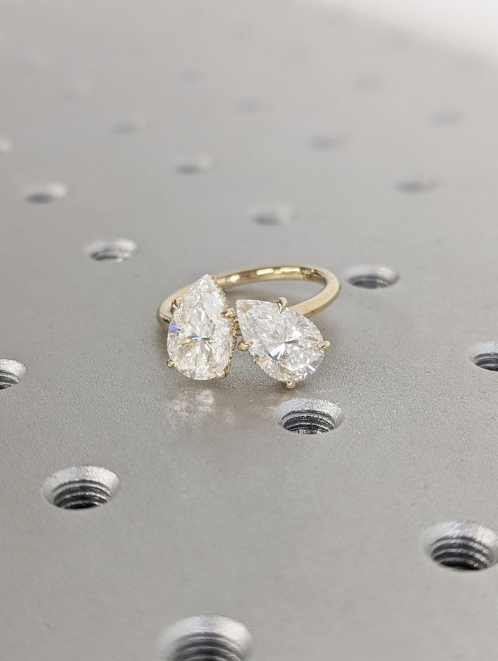 Detailed close-up of pear hidden halo diamond engagement ring