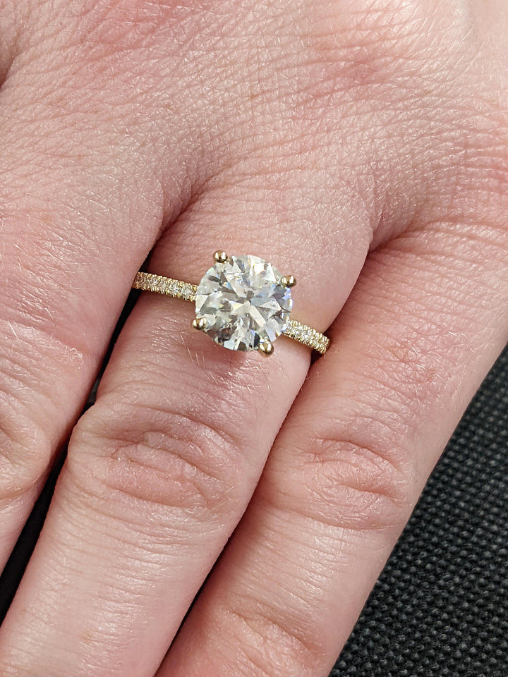 Detailed close-up of round hidden halo diamond engagement ring