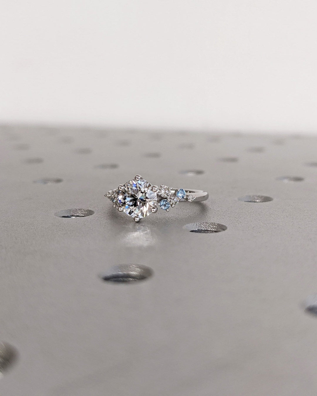 Close-up of round cut center diamond in cluster engagement ring
