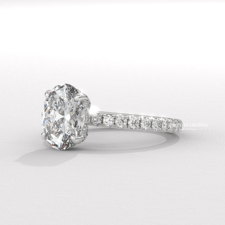 Oval hidden halo engagement ring viewed from the side