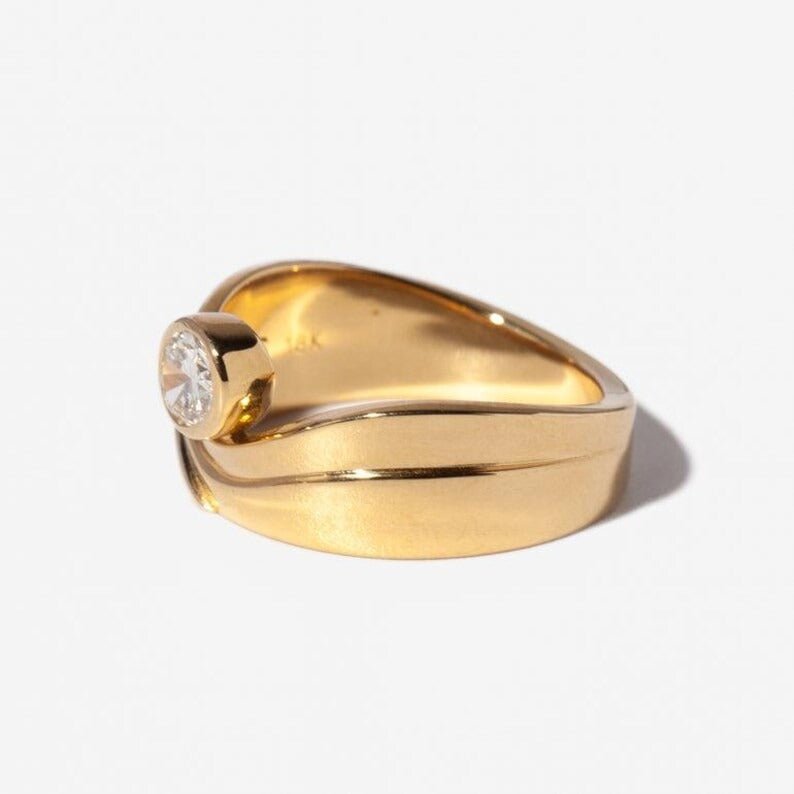 Oval bezel lab grown diamond ring side profile in gold setting