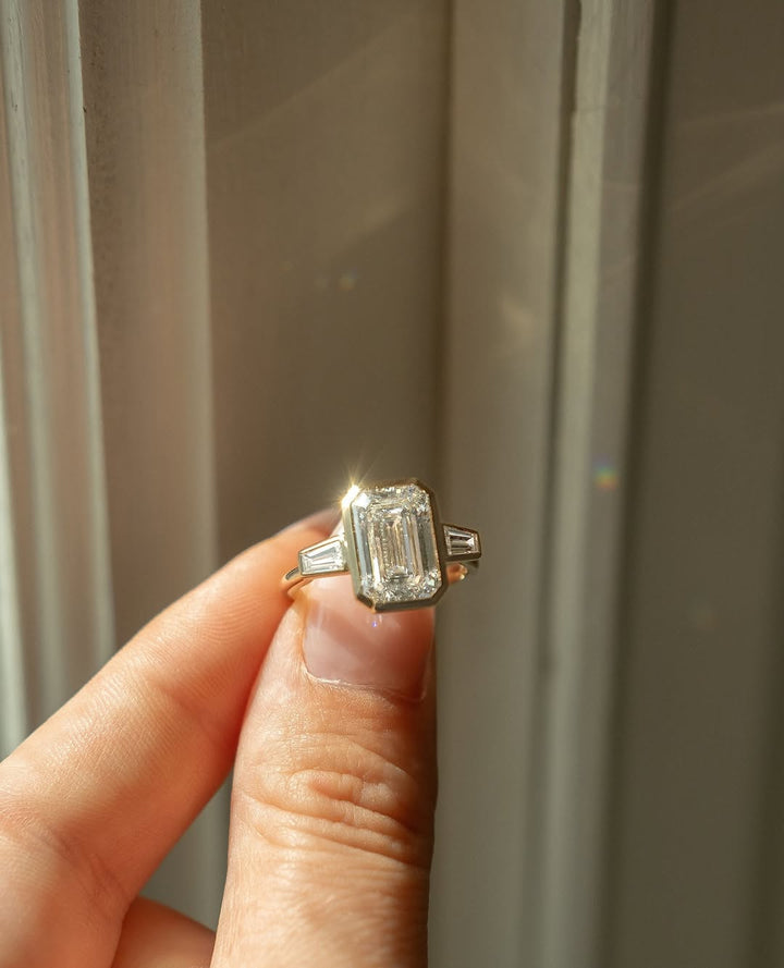 Emerald bezel engagement ring close-up highlighting diamond sparkle