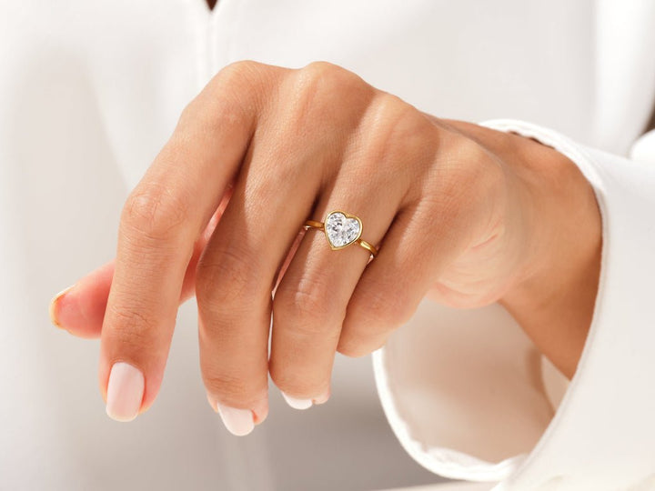 Heart bezel diamond ring displayed on jewelry stand