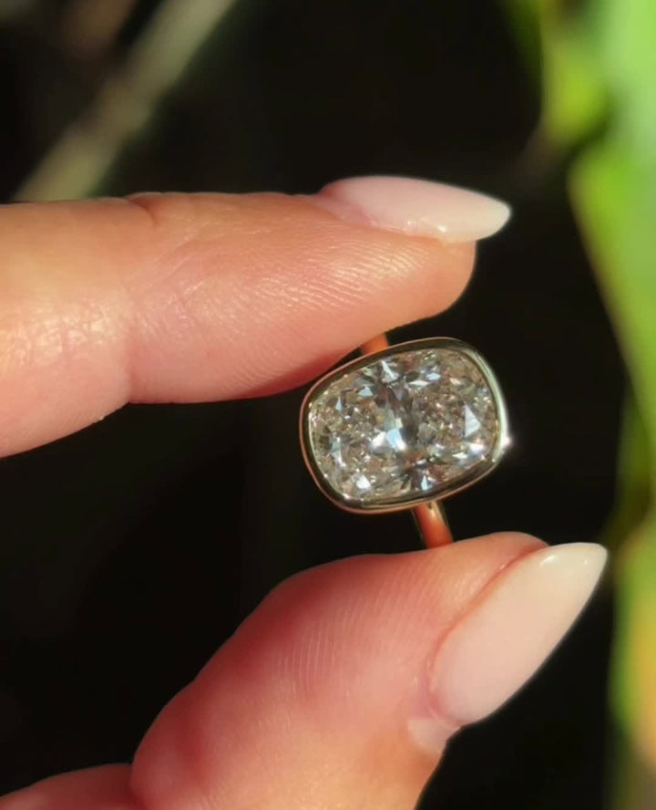 Cushion bezel engagement ring shown on hand for true-to-life sizing