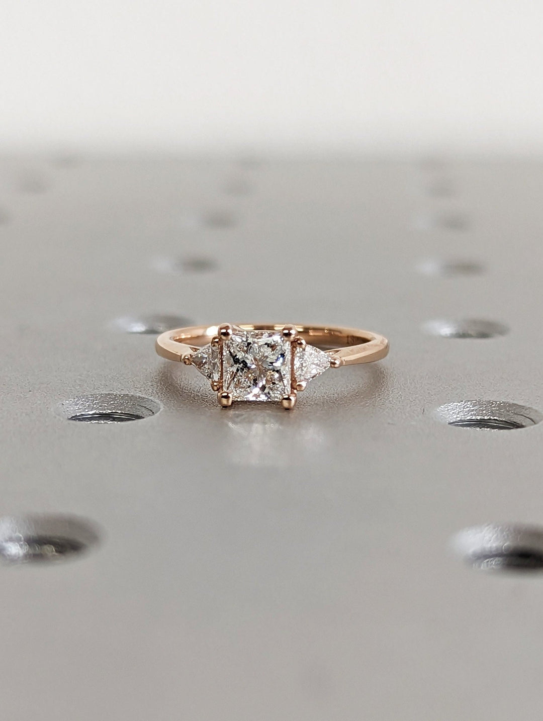 Princess three stone engagement ring finished in polished solid gold