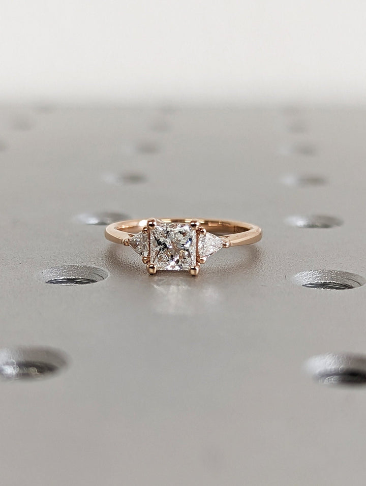 Princess three stone engagement ring finished in polished solid gold