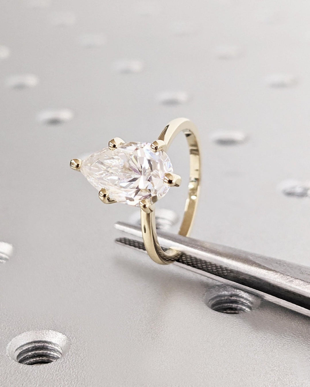 Pear solitaire engagement ring offered in gold and platinum