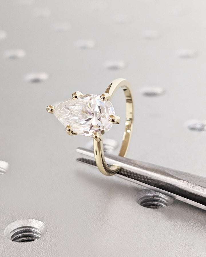 Pear solitaire engagement ring offered in gold and platinum