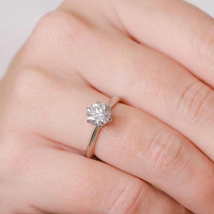 Round solitaire engagement ring close-up showing F/VS2 diamond clarity