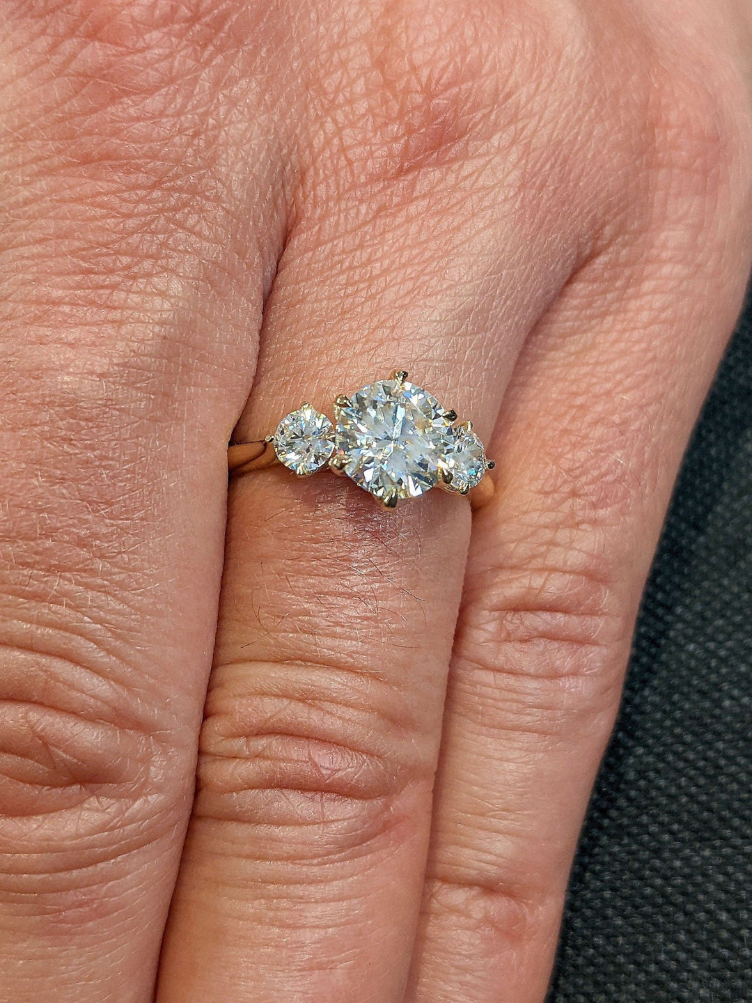 Round three stone engagement ring offered in gold and platinum
