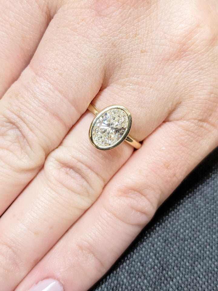 Detailed close-up of oval bezel diamond engagement ring