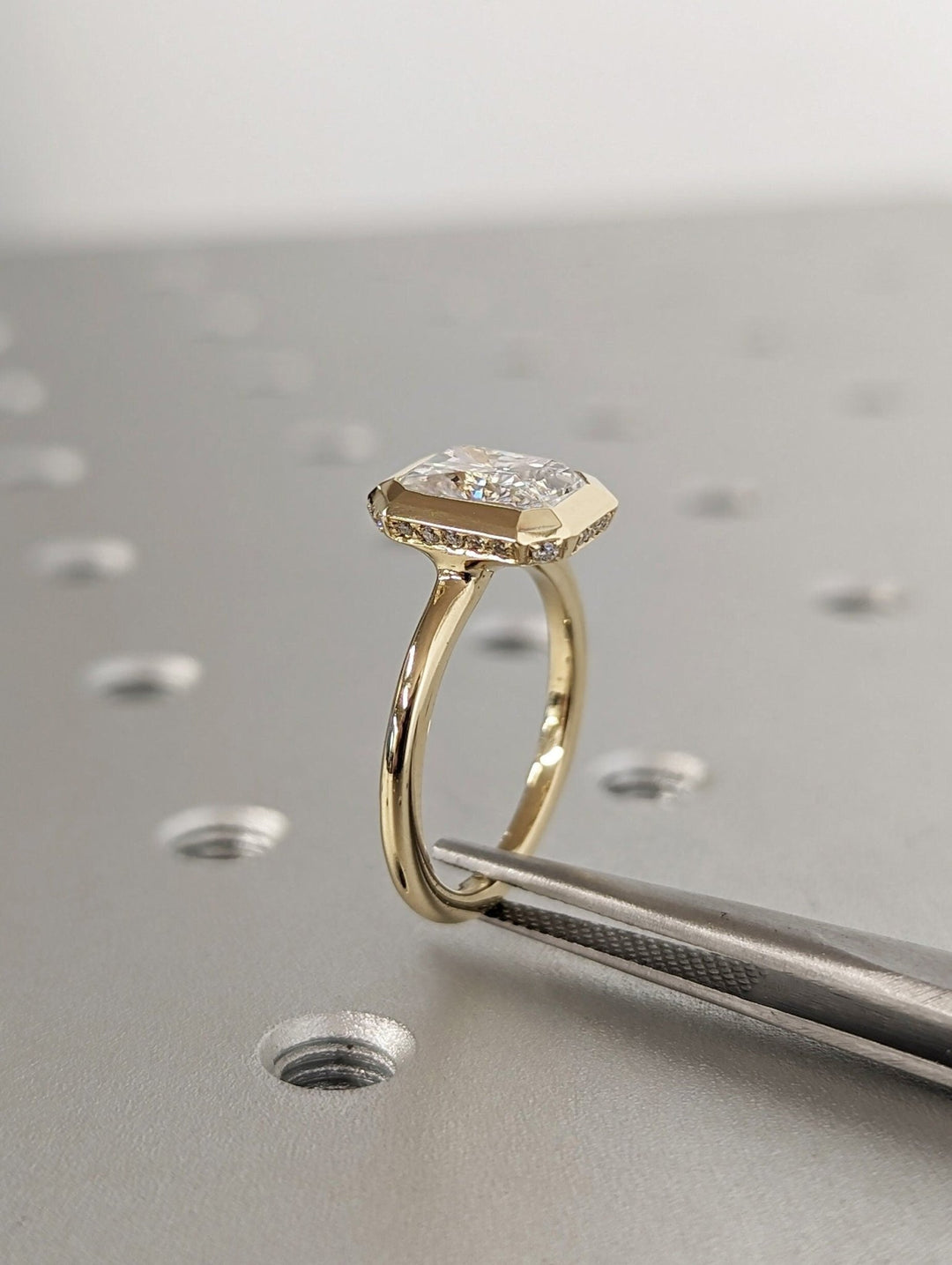 Radiant hidden halo diamond ring displayed on jewelry stand