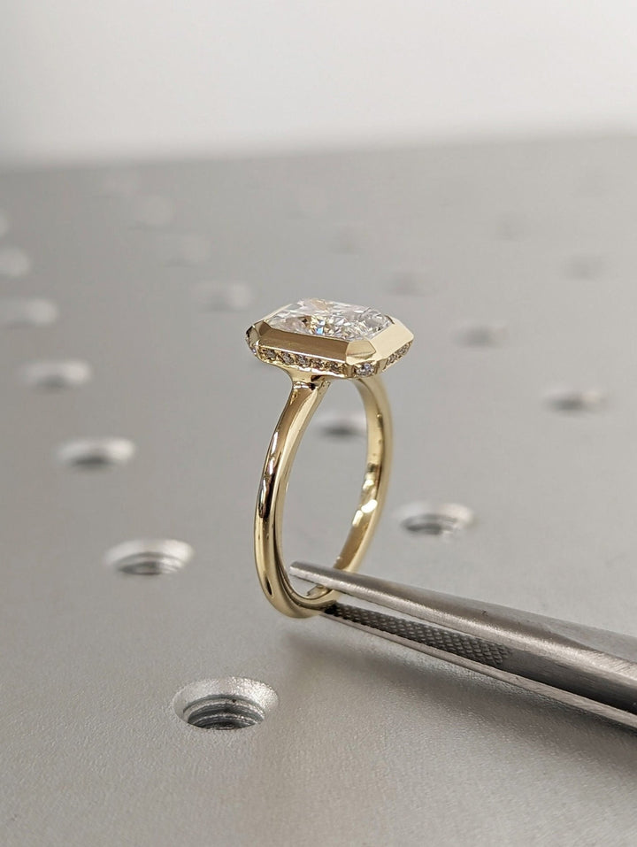 Radiant hidden halo diamond ring displayed on jewelry stand